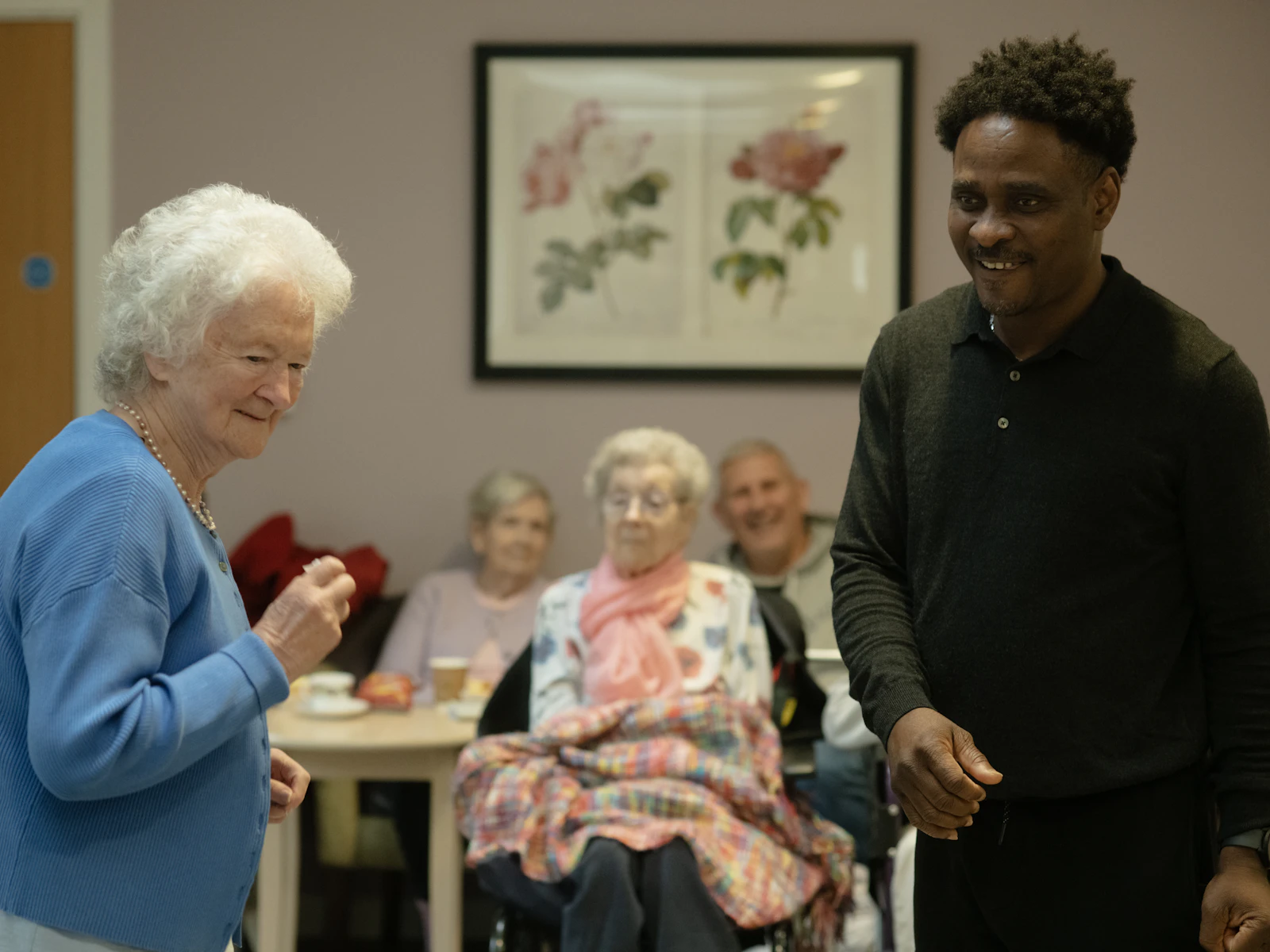 Seniors and a caregiver spending time together in a shared common room